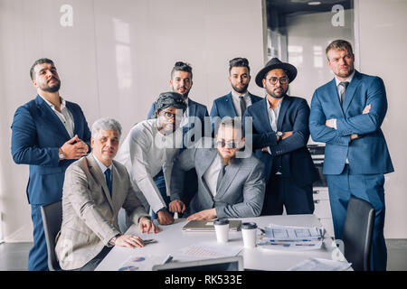 Portrait of ambitious successful business team, consisting of the men only, diverse ethnicity multinational people in stylish suit taking photo togeth Stock Photo