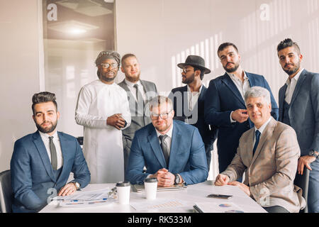 Portrait of ambitious successful business team, consisting of the men only, diverse ethnicity multinational people in stylish suit taking photo togeth Stock Photo