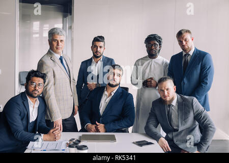 Confident team of age and race diverse male professionals dressed in formal wear excited with success of construction company. Stock Photo