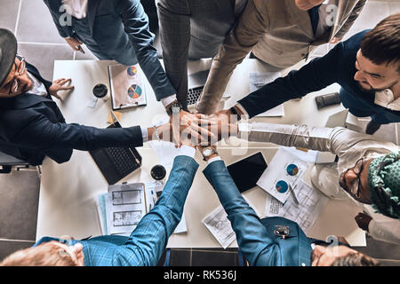 young diverse people standing with folded hands together. top view photo. friendship, partnership, togetherness. Stock Photo