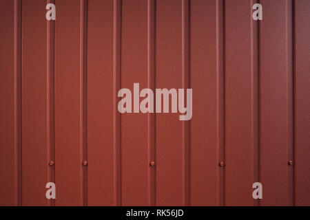 Seamless container pattern. Aluminum fence. Galvanized steel wall plate. Corrugated metal profiled panel. Metal rivets. Background of red metal siding Stock Photo