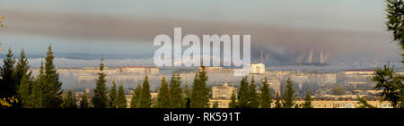 Landscape of smoking chimneys of factories in an industrial city. Dangerous ecology in the industrial city. Smoke and smog from factories and plants. Stock Photo