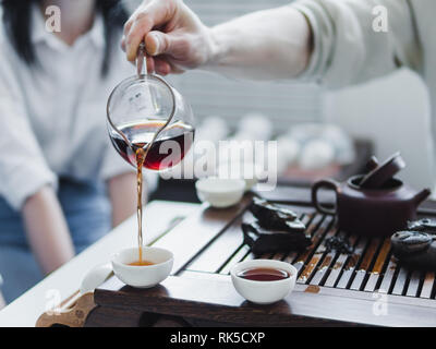 Chinese tea ceremony. Master pouring puer tea in cups. Pu erh tea ceremony. Stock Photo