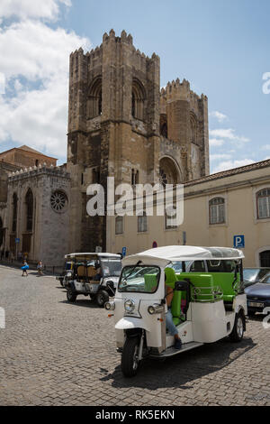 Small taxi cars at the cathedral of Lisbon in the old city Stock Photo