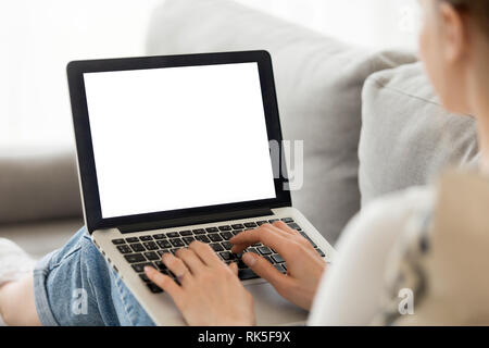 Woman using laptop with blank mockup screen at home Stock Photo