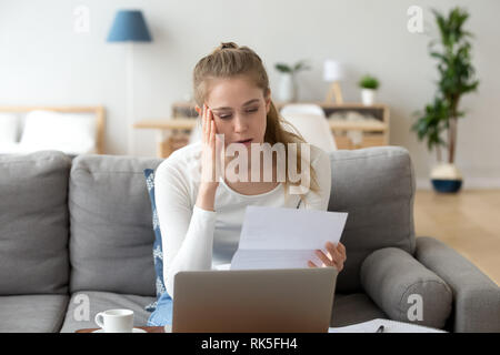 Upset frustrated girl reading bad news in paper letter Stock Photo