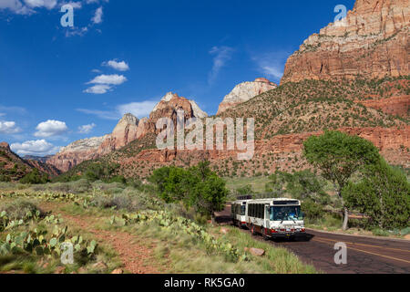 Park shuttle bus in front of Mountain of the Sun and Twin Brothers viewed from close to the visitors centre, Zion National Park, Springdale, UT, USA. Stock Photo