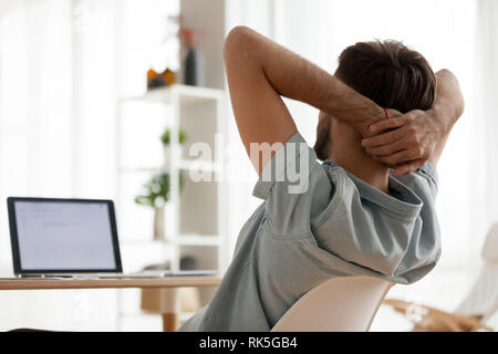 Rear view at relaxed man taking break at work stretching Stock Photo