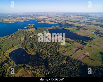 Aerial view of beautiful covered with forest landscape of Mazury region, Stregielek and Stregiel Lakes in the background, Poland