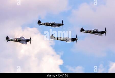 4 Supermarine Spitfires flying over Duxford Stock Photo