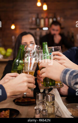 Happy young friends group making a toast about their friendship. Hipster pub. Stock Photo