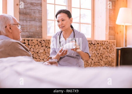 Pleased Asian medical worker giving professional support Stock Photo