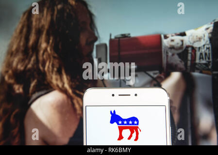 Hong Kong. 8th Feb, 2019. America conservative right-wing Republican party icon is seen on an Android mobile device with a protester using a megaphone in the background. Credit: Miguel Candela/SOPA Images/ZUMA Wire/Alamy Live News Stock Photo