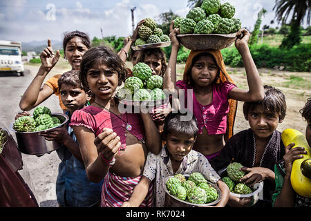 Children selling fruits on highway to earn money Stock Photo