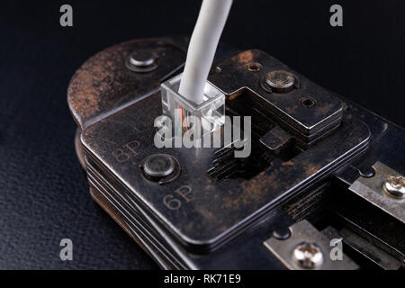 Work in a workshop on connections used in electronics. Computer cables and connectors rj44. Dark background. Stock Photo