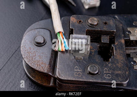 Work in a workshop on connections used in electronics. Computer cables and connectors rj44. Dark background. Stock Photo