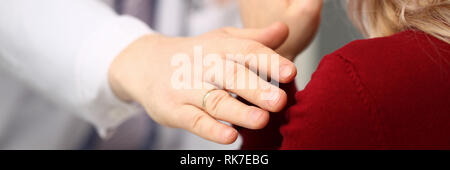 Young male doctor holds sick patient by hand Stock Photo
