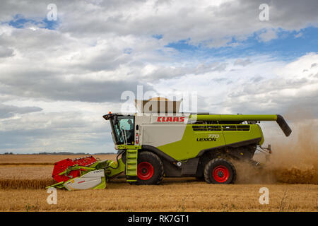 A combine harvester working in a barley field in summertime in Canterbury, New Zealand Stock Photo