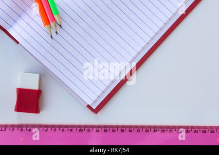 School and drawing supplies, on white bckground. Exercises book, pencils, eraser and ruler. With copy space. Stock Photo