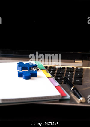 still life with blocknote, labtop, pen and a white mug of coffee over a black office desk. symbol of job Stock Photo