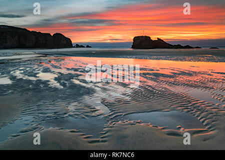 Chapel Rock on Perranporth Beach in Cornwall captured at sunset. Stock Photo