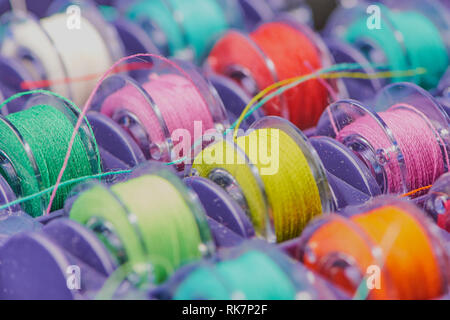 macro of colored cotton thread on yarn bobbins in a box Stock Photo