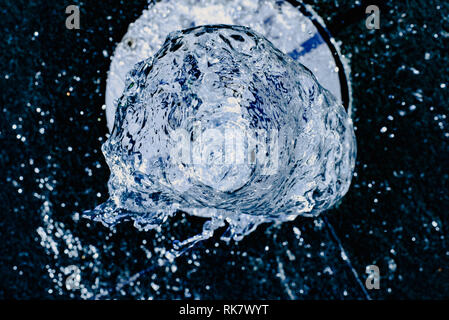 Water jet going up towards the camera, blue tones, background for hydrological concept. Stock Photo