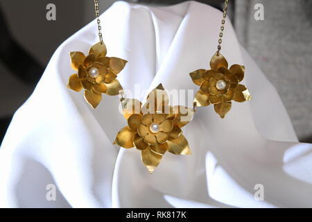 Vintage brass jewelry necklace with pearl on the white satin, hand made Stock Photo
