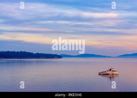 View of the sunset at the ocean with small boat taken at Ladysmith in Vancouver island, Canada Stock Photo