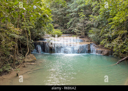 Jangle landscape with flowing turquoise water of Erawan cascade waterfall at deep tropical rain forest. Park Kanchanaburi, Thailand Stock Photo