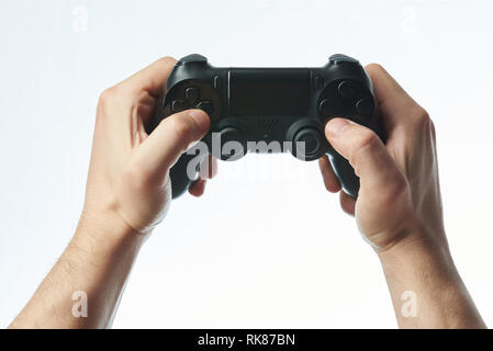 Holding game joystick in hands isolated on white background Stock Photo