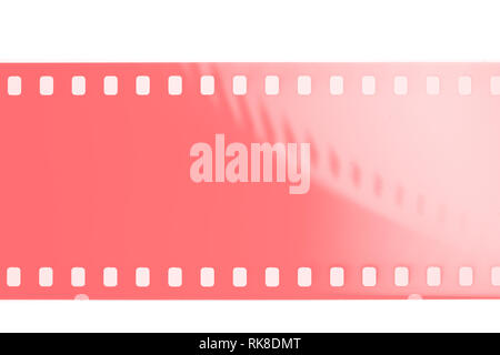 Extreme close up of 35mm movie film strip in living coral colors Stock Photo