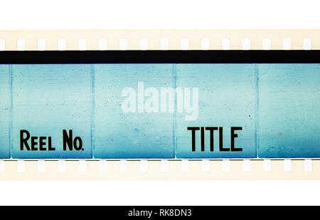 Extreme close up of 35mm movie film strip with reel and title text message on azure Stock Photo