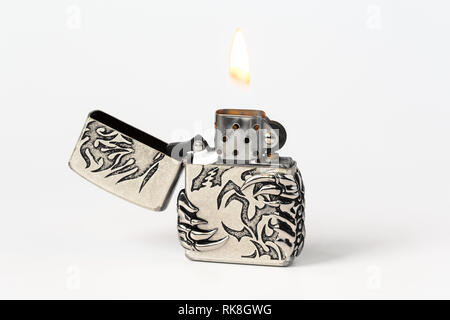 open gasoline lighter with flame on white background closeup Stock Photo