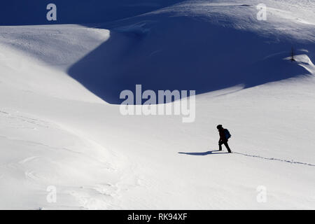 Woman hiking in deep snow on snow covered mountain, Dobratsch, Austria Stock Photo