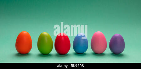 Easter eggs, pastel colors painted, standing in a row, green background, banner Stock Photo