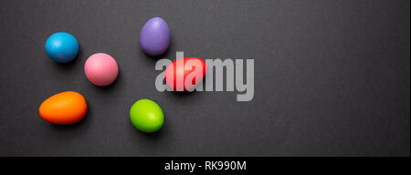 Easter eggs, pastel colors painted on dark gray background, banner, copy space Stock Photo
