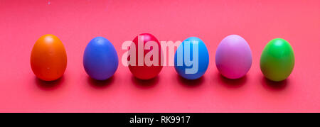 Easter eggs, pastel colors painted, standing in a row, orange color background, banner Stock Photo