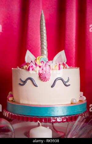Sweet table and big unicorn cake for baby girl first birthday. Stock Photo