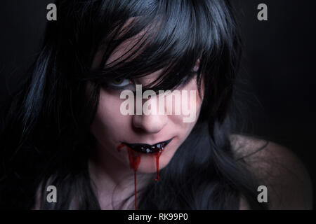 Female zombie with blood in her mouth, Halloween Stock Photo