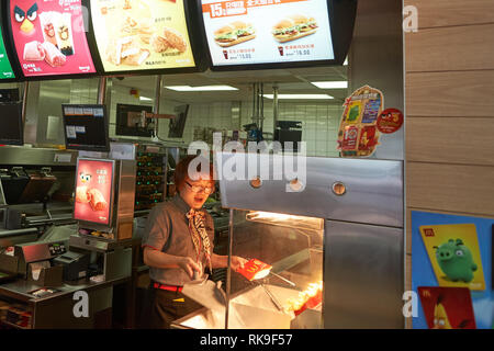 SHENZHEN, CHINA - MAY 06, 2016: worker in McDonald's restaurant. McDonald's is the world's largest chain of hamburger fast food restaurants, founded i Stock Photo