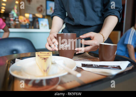 SHENZHEN, CHINA - MAY 06, 2016: barista bring order at McCafe. McCafe is a coffee house style food and drink chain, owned by McDonald's. Stock Photo