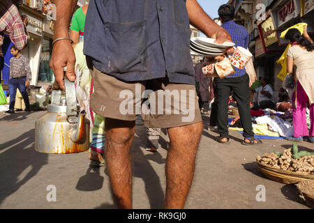 A mobile tea vendor in Mumbai, India, with his teapot, cups and saucers Stock Photo