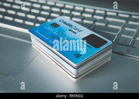 Close up of credit cards set in pile on laptop keyboard. E-commerce concept. Group of credit cards with biometric card on the top. Using fingerprint s Stock Photo