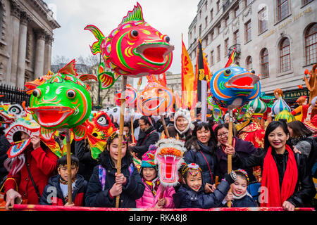 Lion dancers and children in costumes parade around the edges of Chinatown and Soho. Chinese New Year Celebrations in Soho, London. Stock Photo