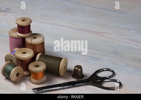 Old spools of thread on a wooden background Stock Photo