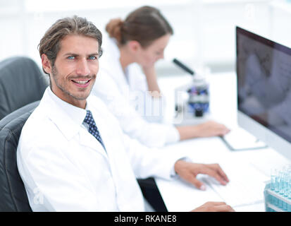 Female Research Scientist Looks at Biological Samples Under Microscope. Stock Photo