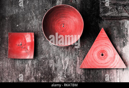 Decorative plates of various shapes on old grunge textured wall. Abstract living coral color toned vintage background Stock Photo