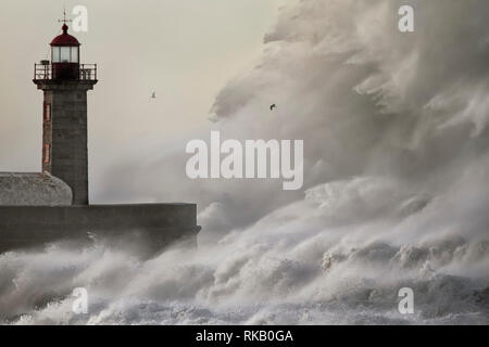 Big stormy sea crashing wave. Douro river mouth old lighthouse and pier, Porto, Portugal. Stock Photo