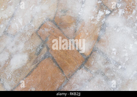 Stone wall covered in partially transparent ice. Stock Photo